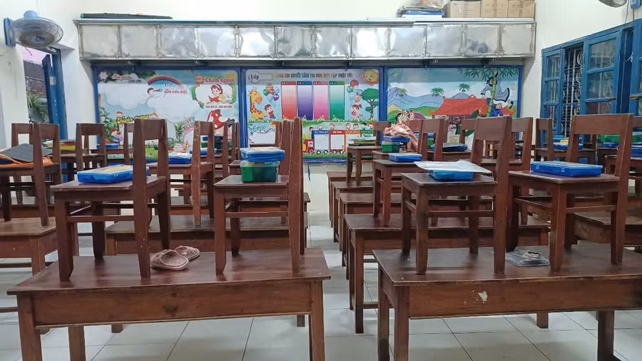 Giáo viên Trường Tiểu học Thủy Biều kê cao bàn, ghế để tránh ngập lụt.