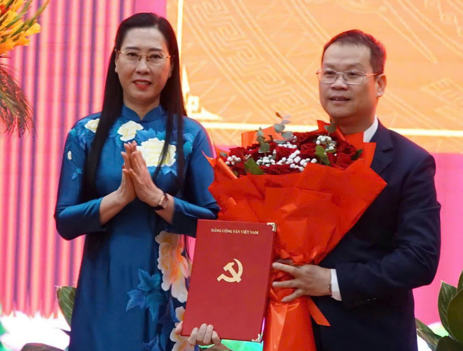 Bà Bùi Thị Quỳnh Vân, Phó Trưởng ban Tổ chức Trung ương trao quyết định và tặng hoa chúc mừng ông Nguyễn Mạnh Hùng. Ảnh: Đ.N