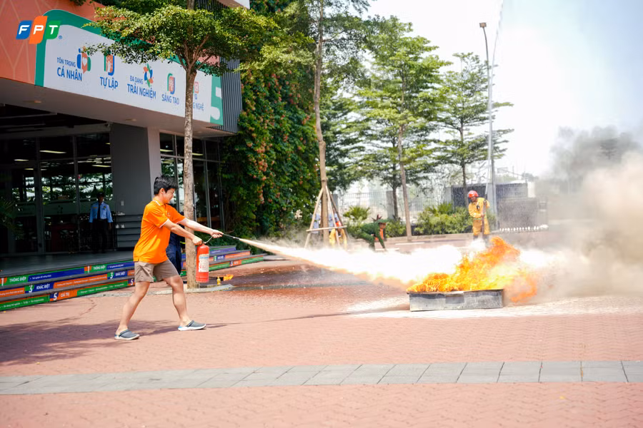 Học sinh học cách dùng bình chữa cháy mini để dập lửa. 