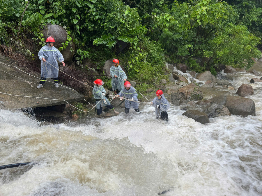 Lực lượng chức năng căng dây đưa thi thể nạn nhân lên bờ. 