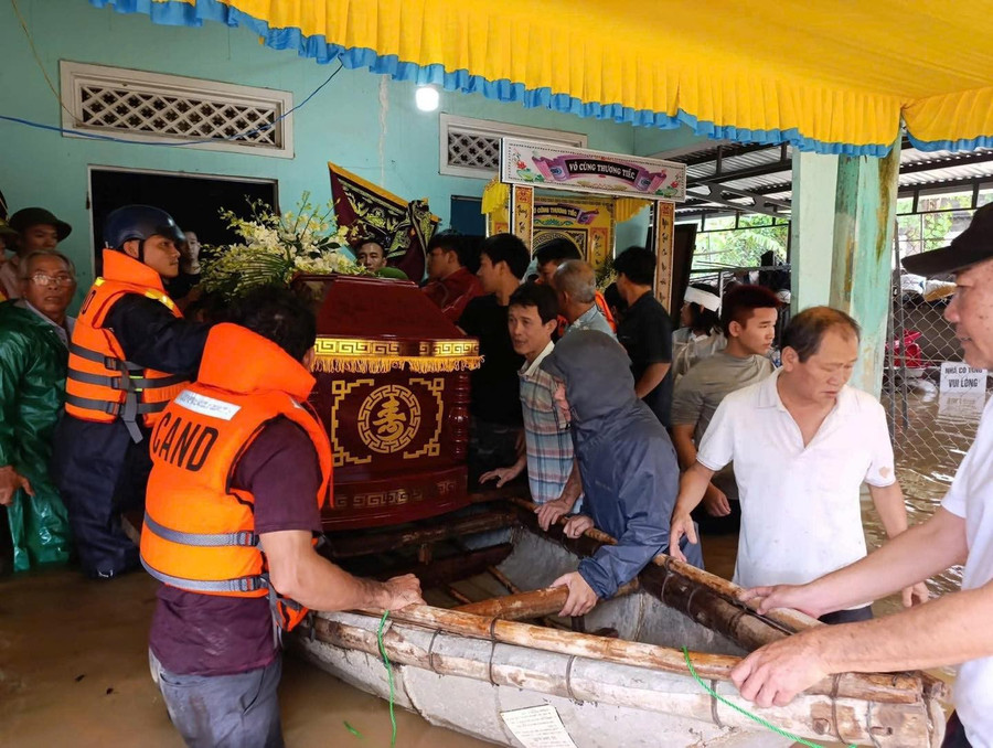 Lực lượng Bộ đội hỗ trợ đưa linh cữu cụ bà T. đi an táng trong điều kiện nước lũ ngập sâu.