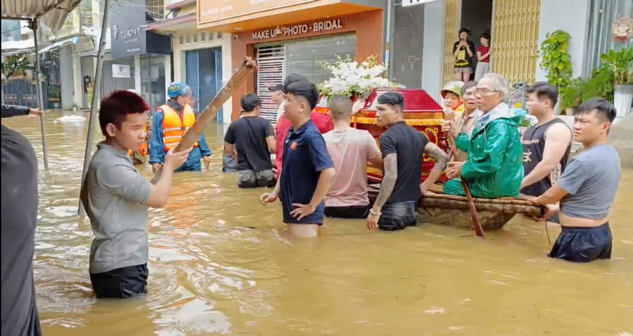 Ông Nguyễn Ngọc Minh (mặc áo mưa xanh) cùng Công an, Bộ đội và người dân chở linh cữu cụ Đối ra nơi cao để đi an táng.