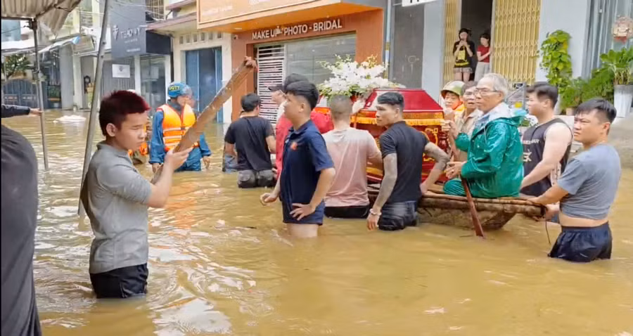Ông Nguyễn Ngọc Minh (mặc áo mưa xanh) cùng Công an, Bộ đội và người dân chở linh cữu cụ Đối ra nơi cao để đi an táng.