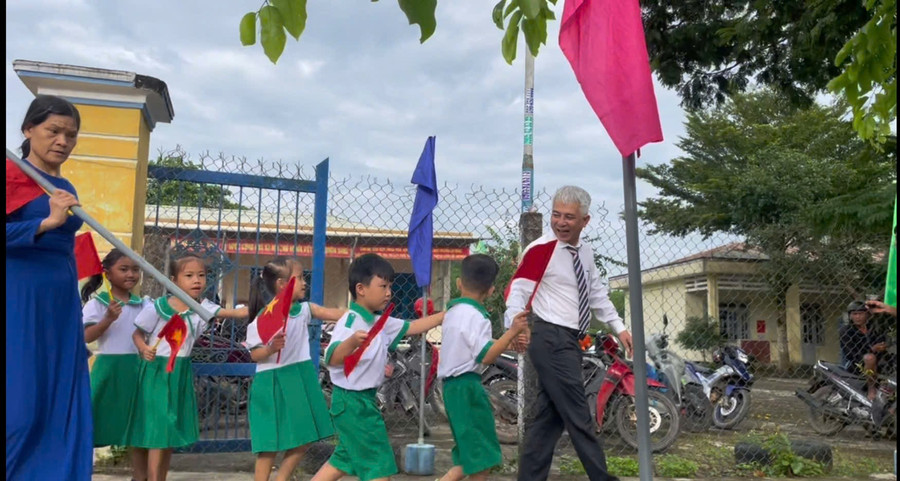 Ông Trần Bảo Tú - Hiệu trưởng Trường Tiểu học Nguyễn Bá Ngọc dắt học sinh lớp 1 vào trường. 8cd3edbbb0893bd76298.jpg