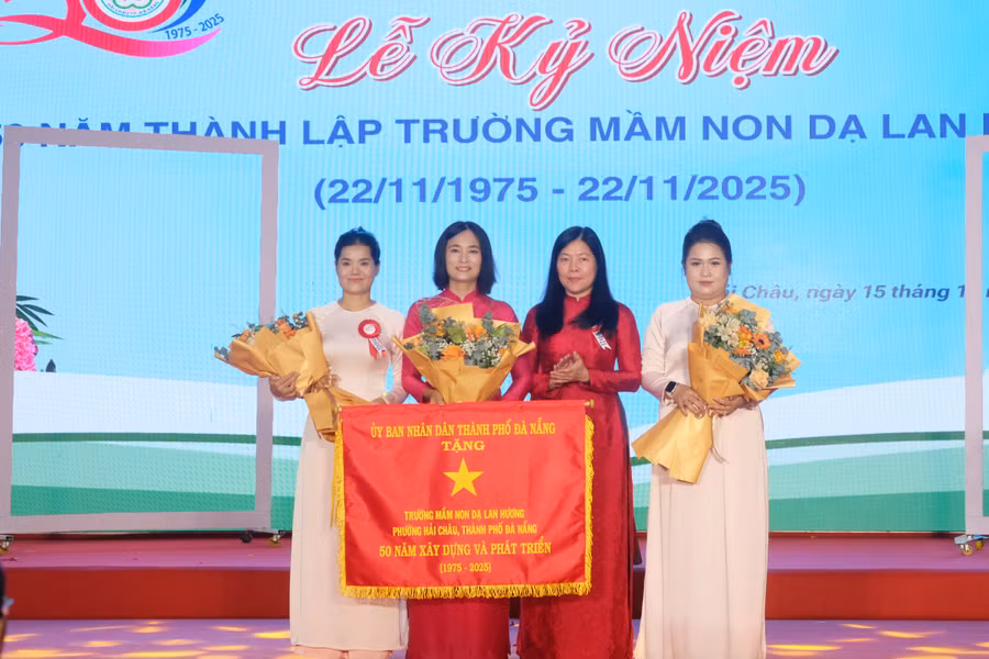 Bà Lê Thị Bích Thuận (thứ 2, từ phải qua) - Giám đốc Sở GD&ĐT TP Đà Nẵng thừa ủy quyền của Chủ tịch UBND TP Đà Nẵng trao cờ lưu niệm cho Ban Giám hiệu Trường Mầm non Dạ Lan Hương.