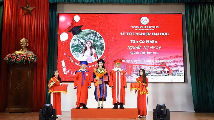 PGS.TS Đoàn Đức Tùng (thứ 2, từ phải sang) và TS Nguyễn Đình Khoa – Phó trưởng khoa Khoa KHXH&NV trao bằng, tặng hoa chúc mừng các tân cử nhân ngành Việt Nam học.