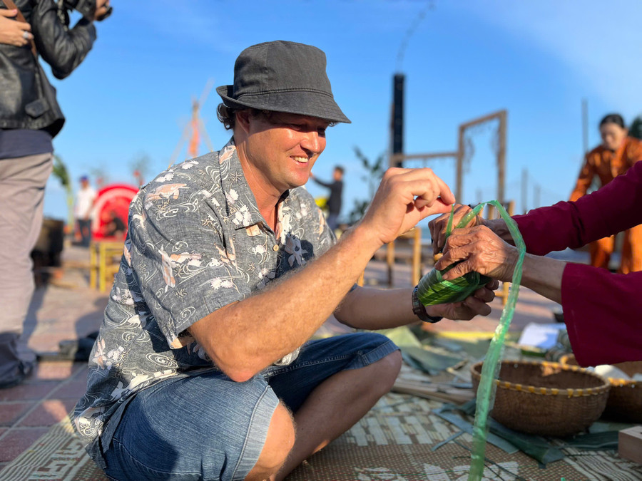 Du khách trổ tài gói bánh chưng.