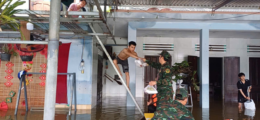 Cán bộ, chiến sĩ Cục Chính trị Quân khu 5 trao cơm cho người dân vùng lũ.