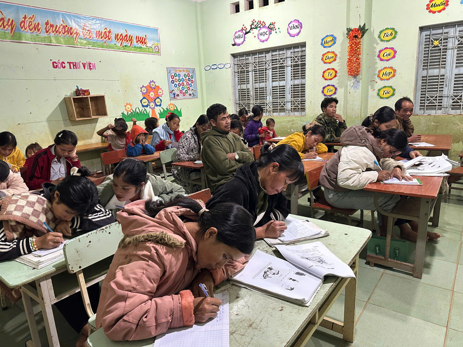 Các học viên lớp học xóa mù chữ chăm chú viết bài.