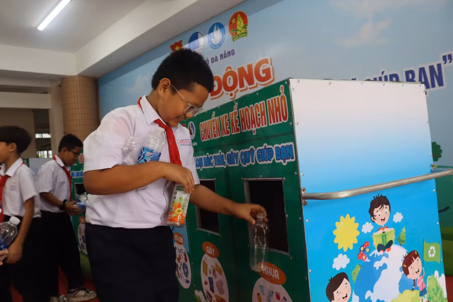 Các em học sinh Trường Tiểu học Ngô Gia Tự (TP Đà Nẵng) bỏ chai nhựa vào chuyến xe kế hoạch nhỏ. 