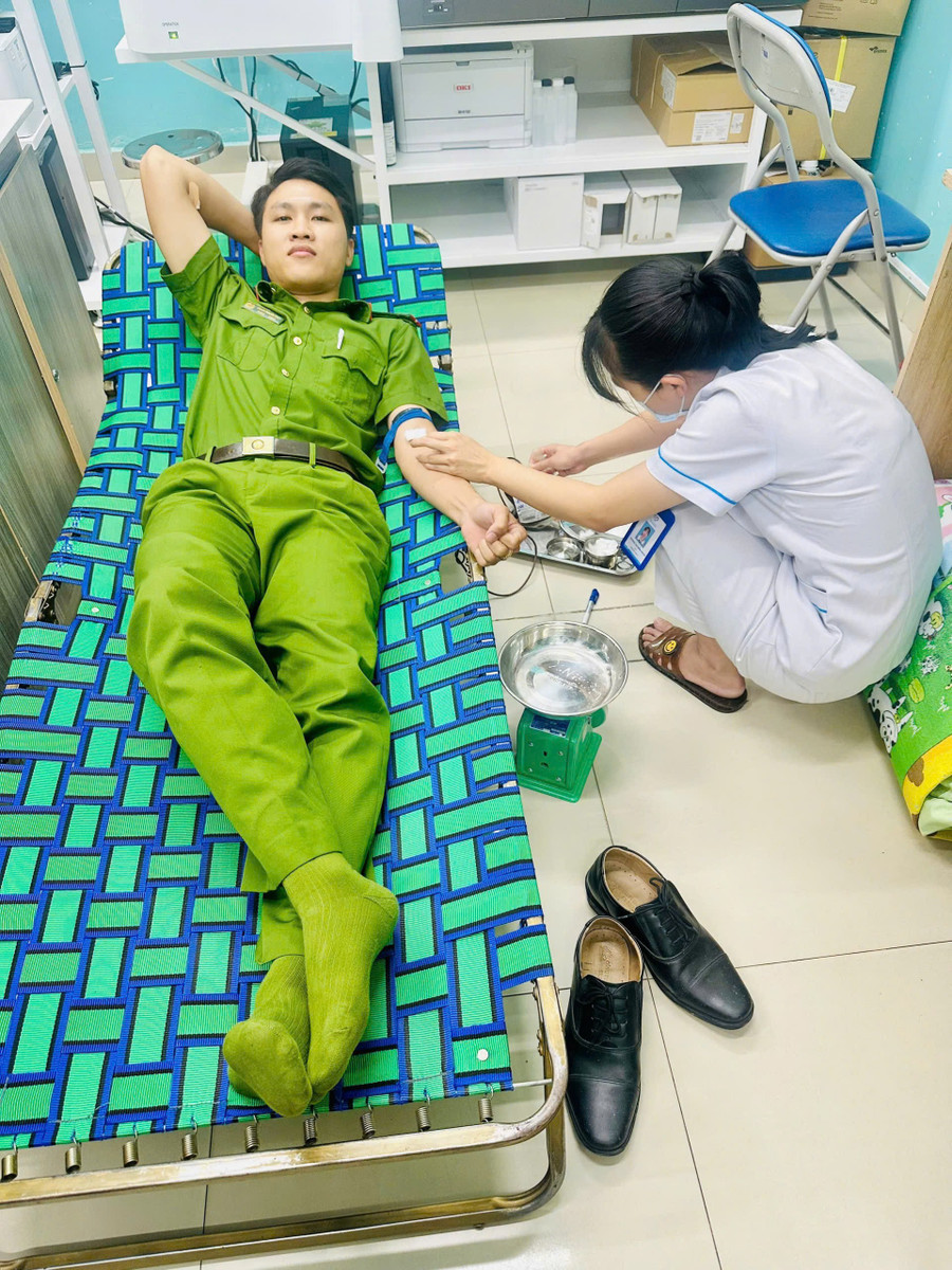 Trung uý Phan Phước Đạt hiến máu để cứu anh Đ. (Ảnh: CACC) 89cb61143d54880ad145.jpg