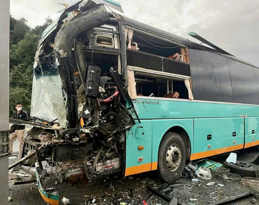 Phần đầu xe khách 50H-302.xx bị hư hỏng nặng sau cú va chạm, nhiều mảnh vỡ kính lái rơi vãi trên mặt đường.