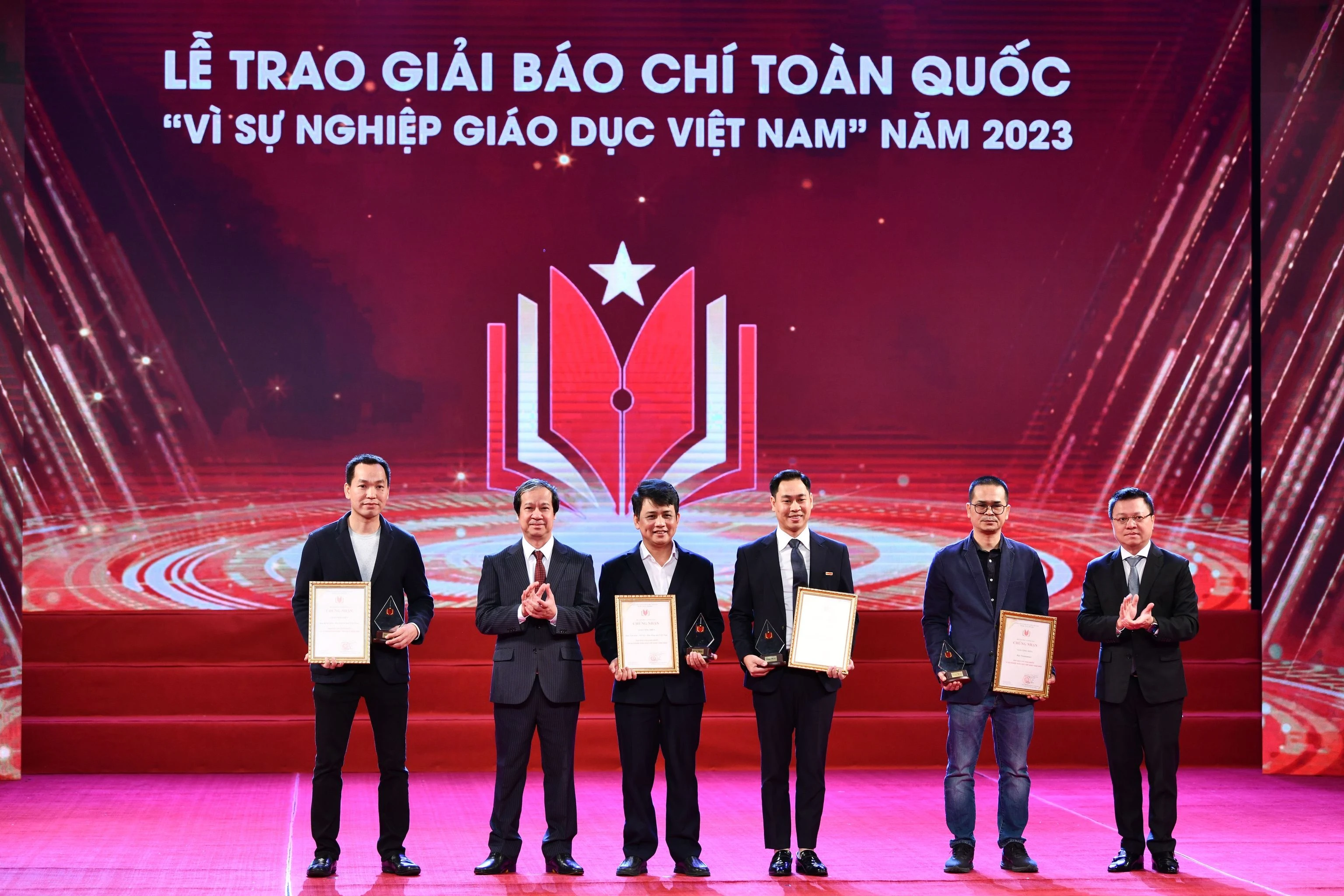 Bộ trưởng Bộ GD&amp;ĐT Nguyễn Kim Sơn và Phó Trưởng ban Tuyên giáo Trung ương, Tổng Biên tập Báo Nhân dân, Chủ tịch Hội Nhà báo Việt Nam Lê Quốc Minh trao giải Cống hiến cho các đơn vị tại Lễ trao giải báo chí toàn quốc 'Vì sự nghiệp Giáo dục Việt Nam' năm 2023.