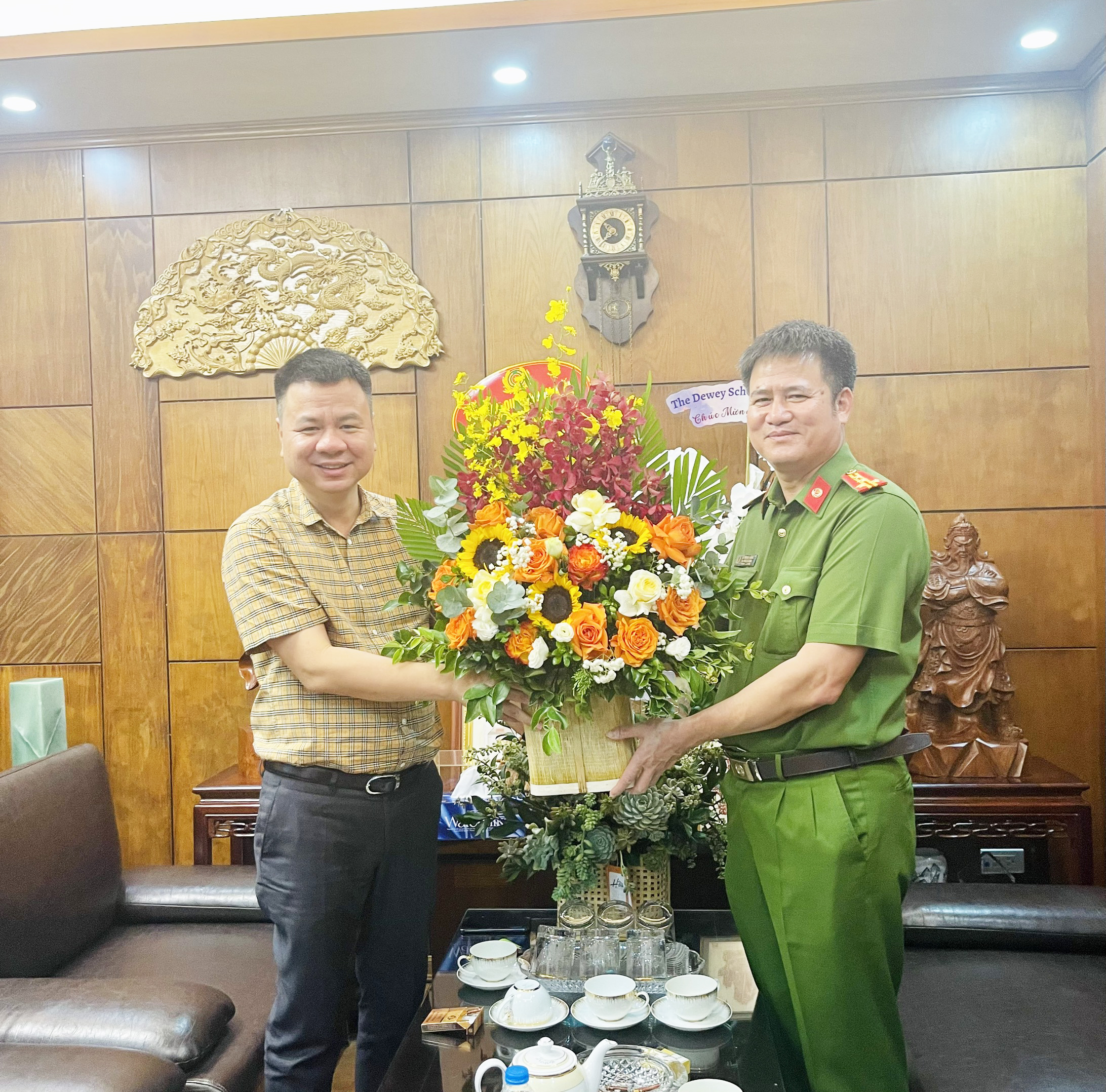 Đại tá Hà Mạnh Hùng, Trưởng Công an quận Hoàn Kiếm tặng hoa chúc mừng.