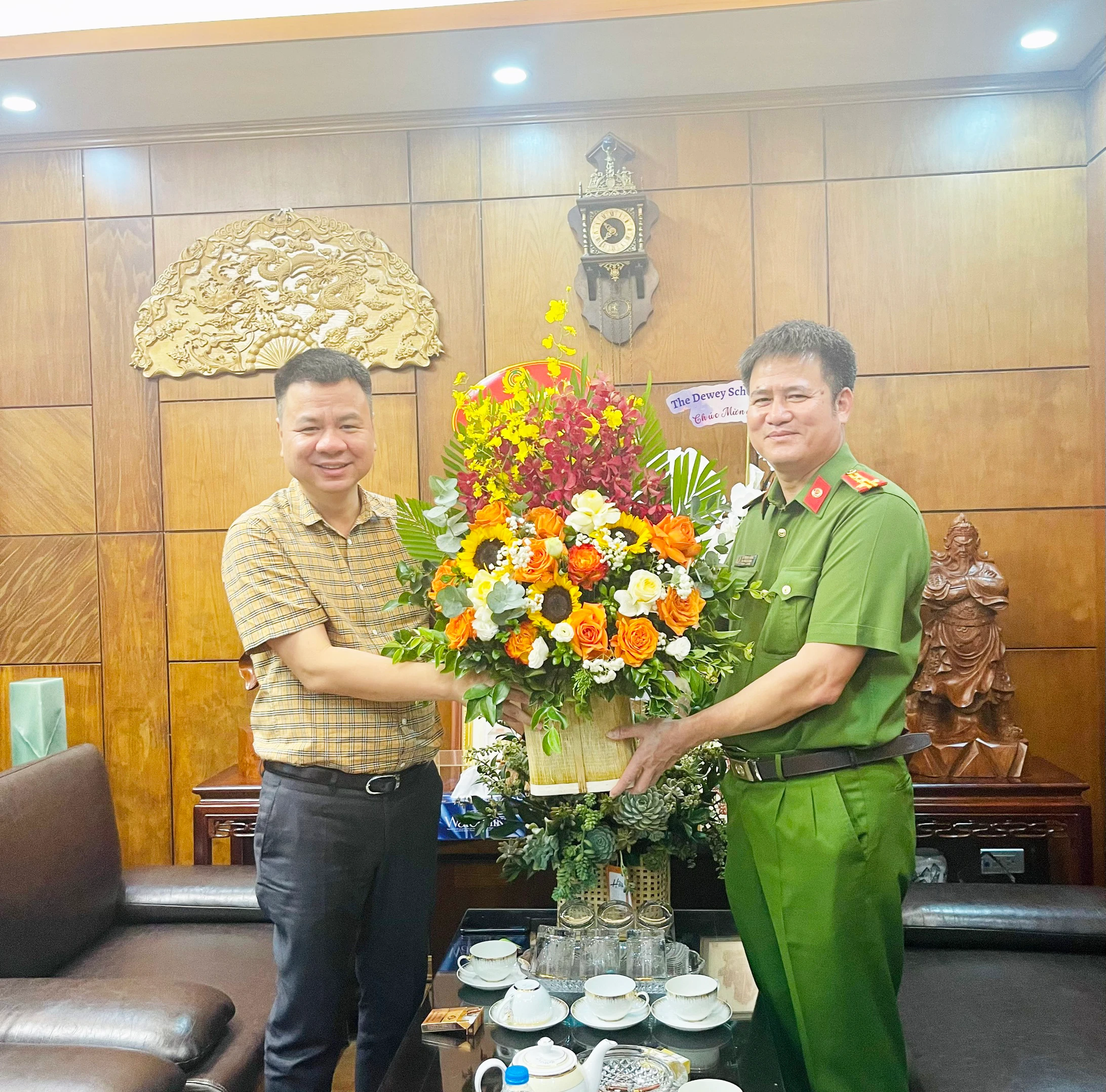 Đại tá Hà Mạnh Hùng, Trưởng Công an quận Hoàn Kiếm tặng hoa chúc mừng.