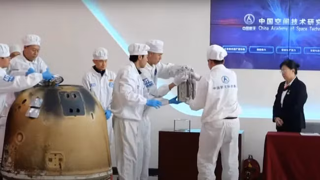 Các kỹ thuật viên lấy các mẫu vật thu thập được ở mặt xa của Mặt Trăng từ viên nang trở về của tàu thăm dò Thường Nga - 6.
