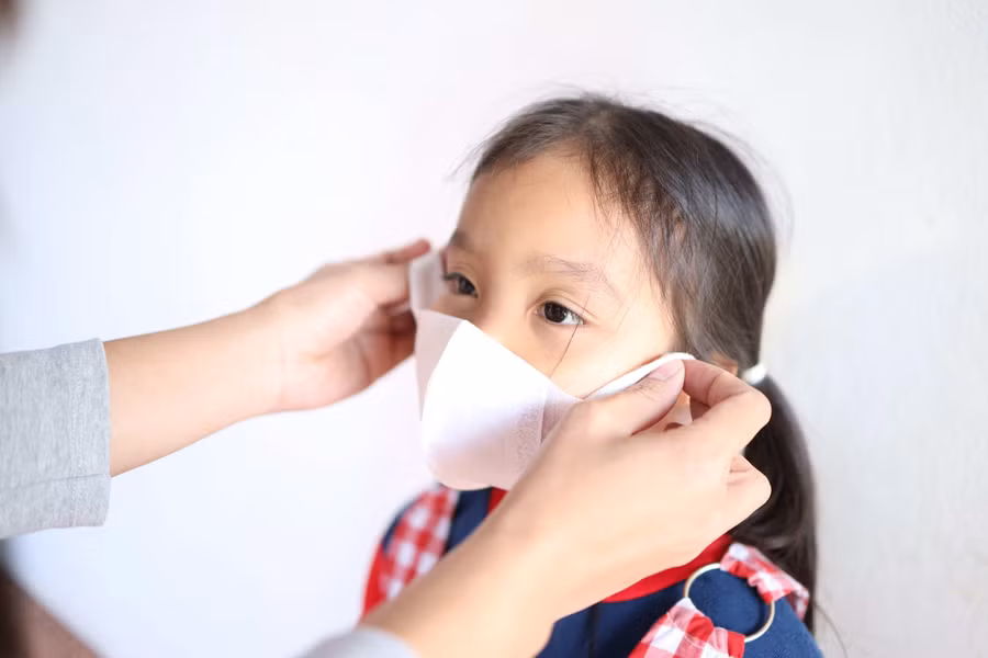 Để phòng bệnh, cha mẹ cần khuyến khích trẻ đeo khẩu trang ở nơi công cộng. Ảnh minh họa: INT