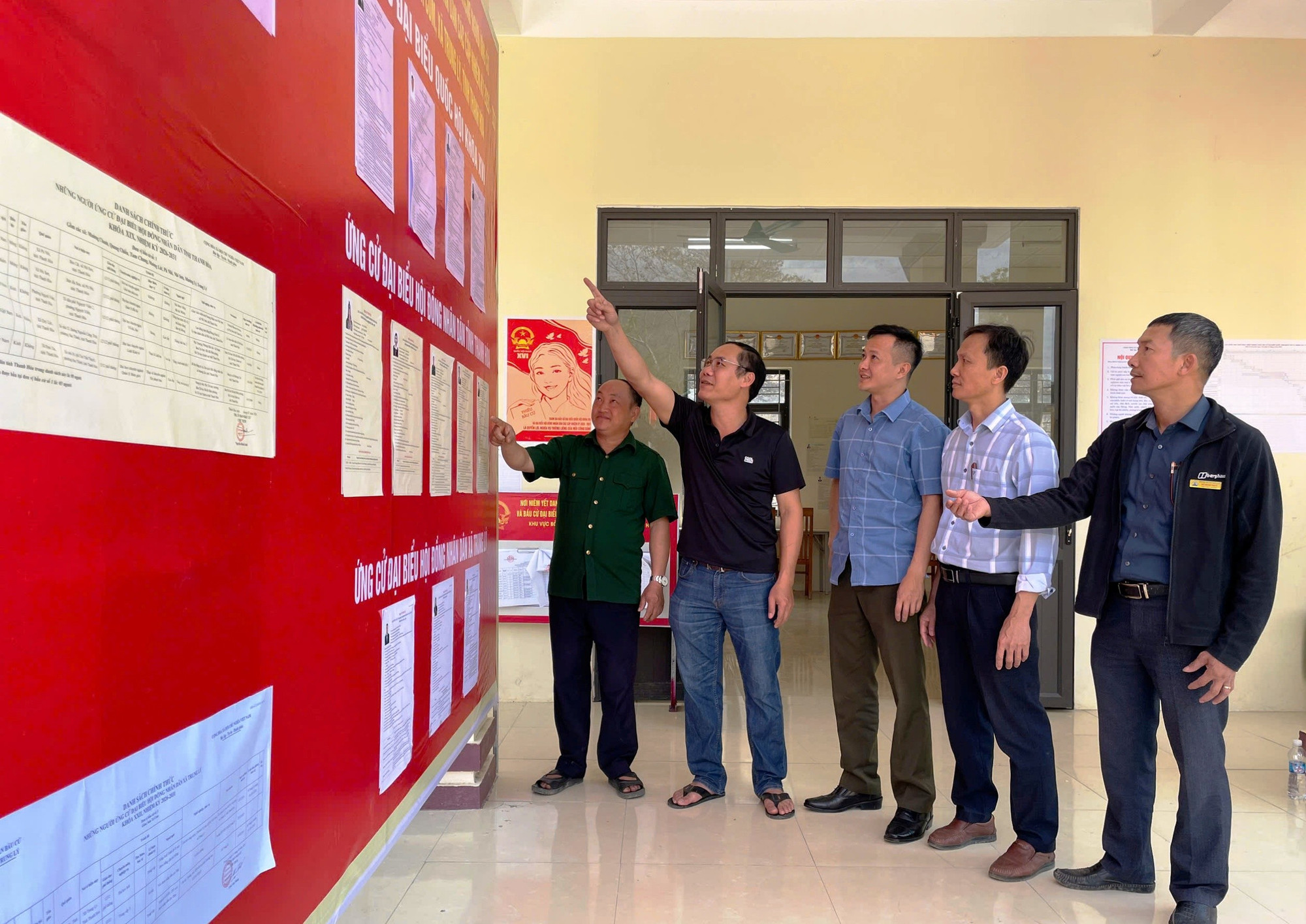 Kiểm tra bảng niêm yết danh sách người ứng cử đại biểu và cử tri ở điểm bầu cử Tà Cóm (Thanh Hóa).