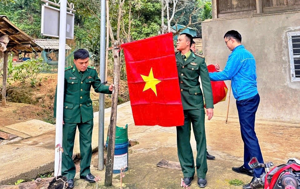 Các chiến sĩ Đồn Biên phòng Cửa khẩu Quốc tế Na Mèo (Thanh Hóa) giúp người dân cắm cờ Tổ quốc.