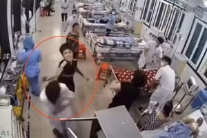 Người đàn ông dùng tay tác động vào vùng đầu, mặt nhân viên y tế. Ảnh cắt từ clip