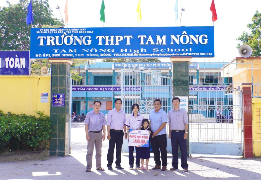 Đại diện Trường ĐH Đồng Tháp trao tặng số tiền động viên, tiếp sức hai chị em Trương Thị Nhu Mỹ.