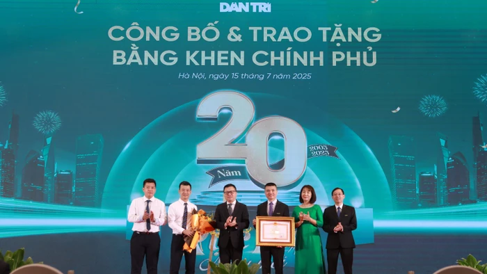 Nhà báo Lê Quốc Minh, Tổng Biên tập Báo Nhân Dân, Phó Trưởng Ban Tuyên giáo và Dân vận Trung ương trao Bằng khen của Thủ tướng cho Báo Dân trí. (Ảnh: Đình Tuệ)