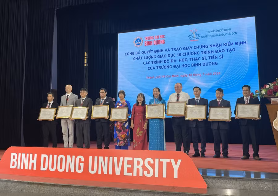 Cán bộ, giảng viên Trường Đại học Bình Dương đại diện cho 10 ngành đào tạo nhận chứng nhận kiểm định. Ảnh: Hà An.