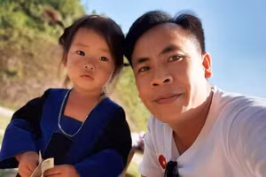 Nhà báo Hoàng Đình Giang chụp ảnh với một trẻ em vùng biên Mường Lát (Thanh Hóa). Ảnh: NVCC