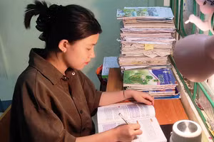 Em Lương Thị Kiều, học sinh lớp 12C2, Trường THPT Mường Lát đang tranh thủ ôn lại bài để vào phòng thi. Ảnh: Thế Lượng