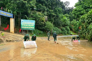 Cán bộ, chiến sỹ Đồn Biên phòng Trung Lý giúp Trường Tiểu học Trung Lý 1 khắc phục hậu quả thiên tai. (Ảnh: Hoàng Anh) 