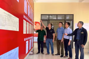 Kiểm tra bảng niêm yết danh sách người ứng cử đại biểu và cử tri ở điểm bầu cử Tà Cóm (Thanh Hóa).