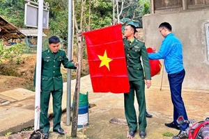 Các chiến sĩ Đồn Biên phòng Cửa khẩu Quốc tế Na Mèo (Thanh Hóa) giúp người dân cắm cờ Tổ quốc.