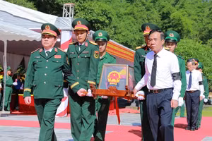 Đại tướng Nguyễn Trọng Nghĩa (trái) và Bí thư Tỉnh ủy Thanh Hóa Lê Đức Thái (phải) đưa hài cốt liệt sĩ đến nơi an nghỉ tại Nghĩa trang Liệt sĩ Quốc tế Đồng Tâm. Ảnh: Minh Hiếu.