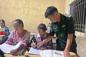 Cán bộ Đồn Biên phòng Trung Lý (Thanh Hóa) dạy chữ cho đồng bào Mông. 