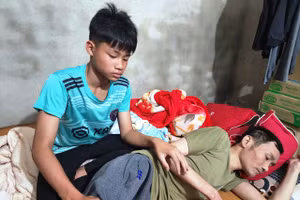Nguyễn Xuân Nam chăm sóc người cha liệt giường.