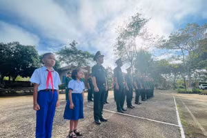 Hai em Tuấn và Tuyền thực hiện nghi thức chào cờ cùng các chú bộ đội.