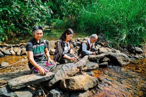 Nghệ nhân kiểm tra âm thanh các phiến đá trong thiên nhiên. Ảnh: Bảo tàng Đắk Nông.
