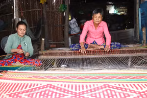 Bà Lê Thị Nhất và con gái đang dệt chiếu. 
