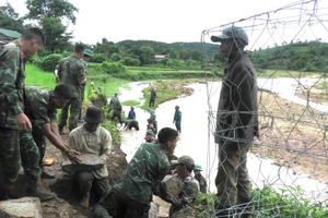 Từng viên đá được bộ đội và người dân chuyền tay nhau đưa xuống phía dưới bờ suối.