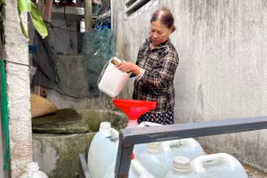 Giữa trưa, bà Trương Thị Hằng mang gàu vét chút nước còn sót lại ở chiếc giếng nước ngọt duy nhất của làng.