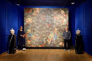 Họa sĩ Nguyễn Thế Hùng (bên phải) bên một tác phẩm tại triển lãm 'Bắt đầu, ở mọi nơi'.