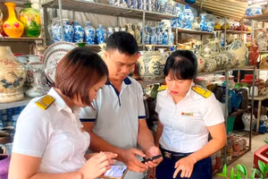 Cán bộ thuế thành phố Hải Phòng hỗ trợ trực tiếp người dân, hộ kinh doanh cài đặt ứng dụng thuế điện tử eTax Mobile. Ảnh minh họa: INT