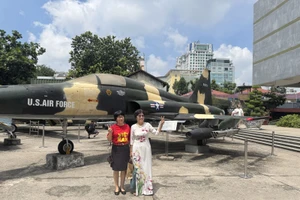 Du khách chụp hình lưu niệm trong khuôn viên Bảo tàng Chứng tích chiến tranh.