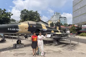 Du khách chụp hình lưu niệm trong khuôn viên Bảo tàng Chứng tích chiến tranh.