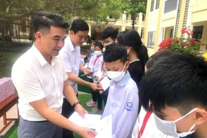 Nhà báo, Trung tá Đặng Trung Kiên tặng quà cho các em học sinh nghèo vượt khó trong chương trình thiện nguyện 'Nâng bước em đến trường'. Ảnh: NVCC