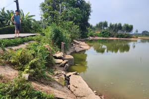 Hạ lưu cống xả đáy (bên trái) và tràn xả lũ (bên phải) bị vỡ gây nguy cơ sạt lở đất.