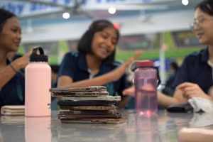 Học sinh Trường Trung học Swiss Cottage, Singapore, xếp chồng điện thoại lên bàn vào giờ ra chơi.