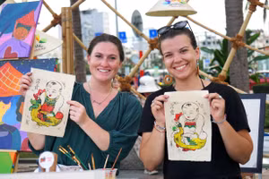 Du khách hào hứng khi trải nghiệm làm tranh Đông Hồ trên giấy dó. Ảnh: INT.