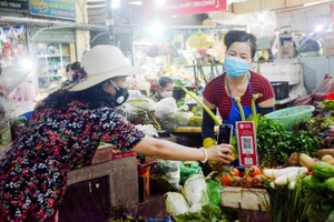 Người dân mua sắm và thanh toán tiền qua hình thức quét mã QR Code tại chợ Thắng Nhất (TP Vũng Tàu, Bà Rịa - Vũng Tàu). Ảnh minh họa: INT