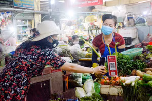 Người dân mua sắm và thanh toán tiền qua hình thức quét mã QR Code tại chợ Thắng Nhất (TP Vũng Tàu, Bà Rịa - Vũng Tàu). Ảnh minh họa: INT